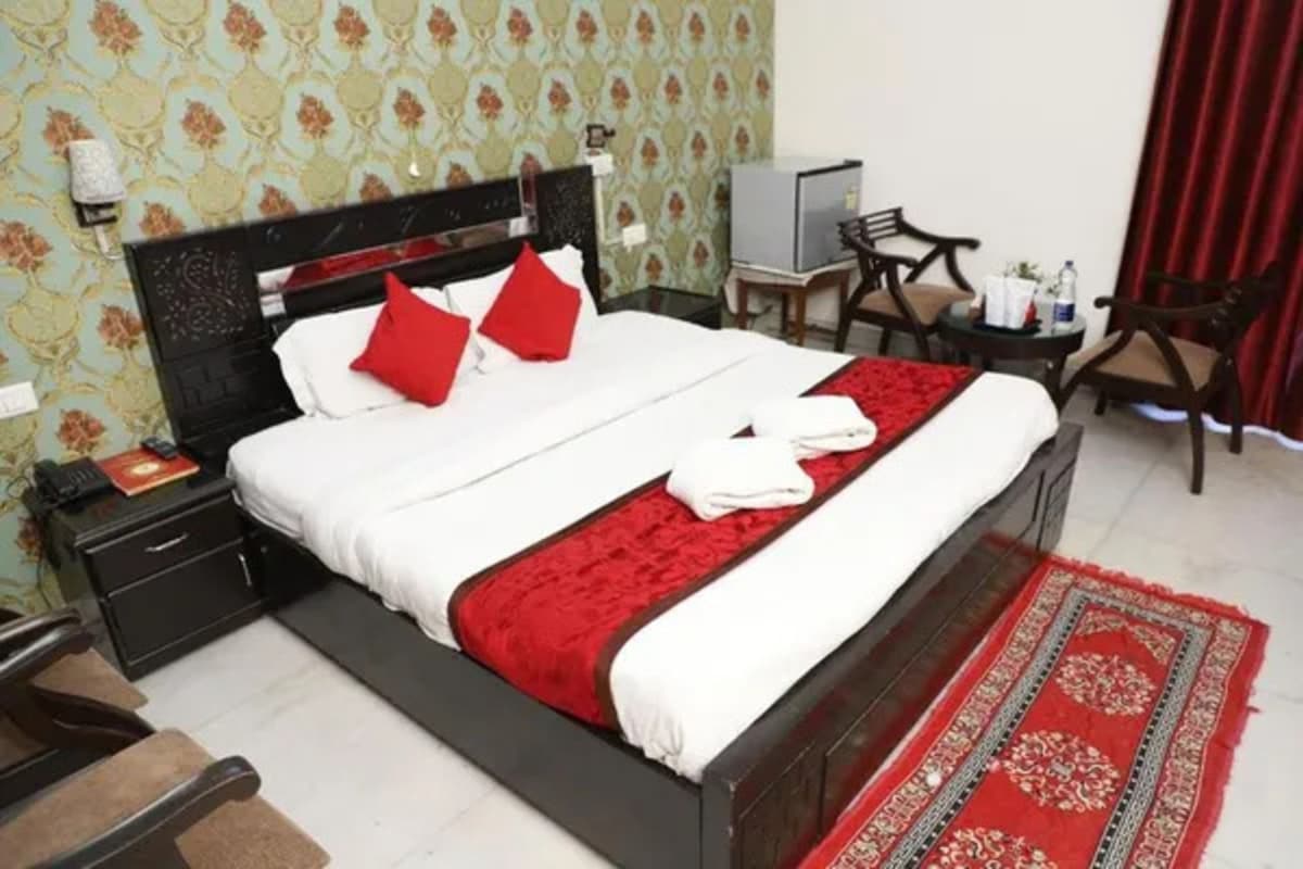 Une chambre d’hôtel avec un lit, un bureau, une chaise et un téléviseur.