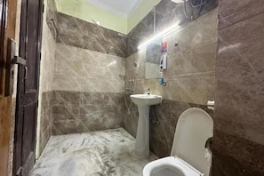 A bathroom with a toilet, sink, and shower.
