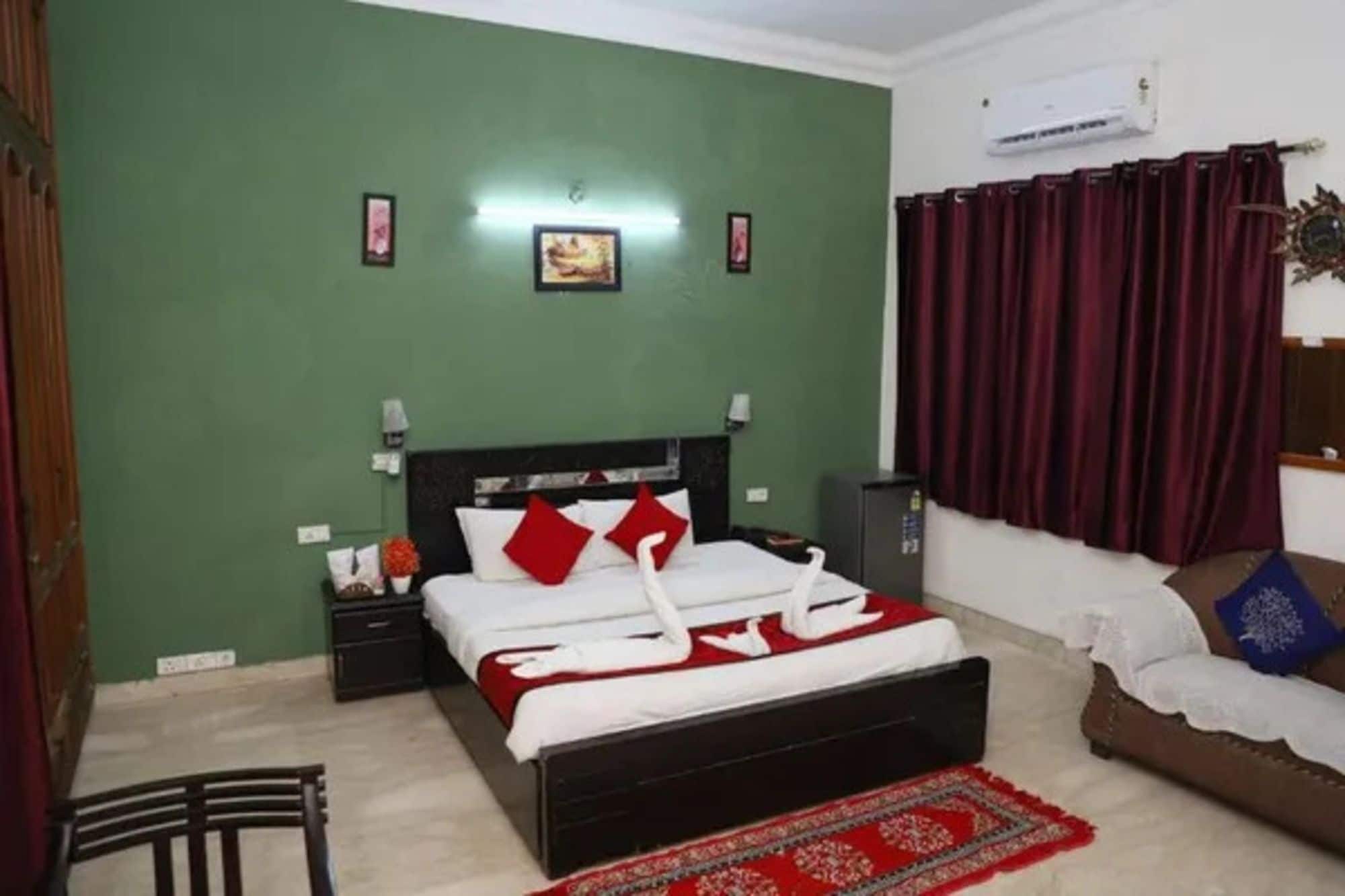 A bedroom with a bed, a nightstand, a dresser, a red rug, and a window with curtains.