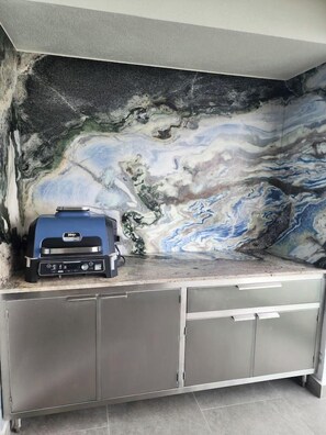A kitchen with a marble backsplash and a built-in grill station. - Amazing Sunsets are just the beginning! (Puerto Vallarta)