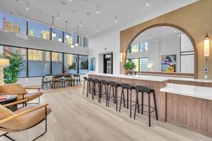 A modern bar area with high ceilings, large windows, and a city view. - Modern 1BR | Pool & Gym Access | Downtown Miami (Miami)