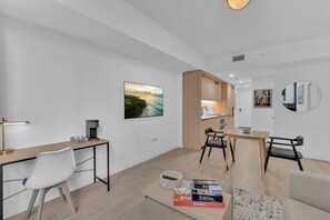A modern, well-lit room with a desk, chairs, a dining area, and artwork on the walls. - Modern 1BR | Pool & Gym Access | Downtown Miami (Miami)