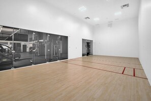 A squash court with a wooden floor and glass walls. - Modern 1BR | Pool & Gym Access | Downtown Miami (Miami)
