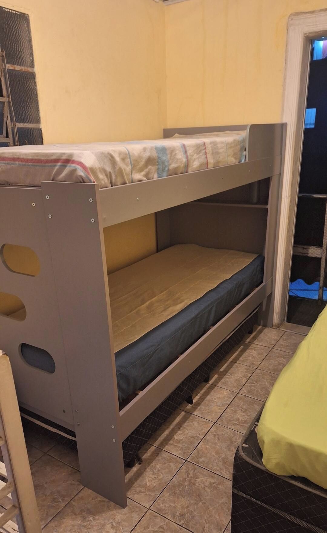 Un lit superposé avec un matelas et un bureau escamotable.