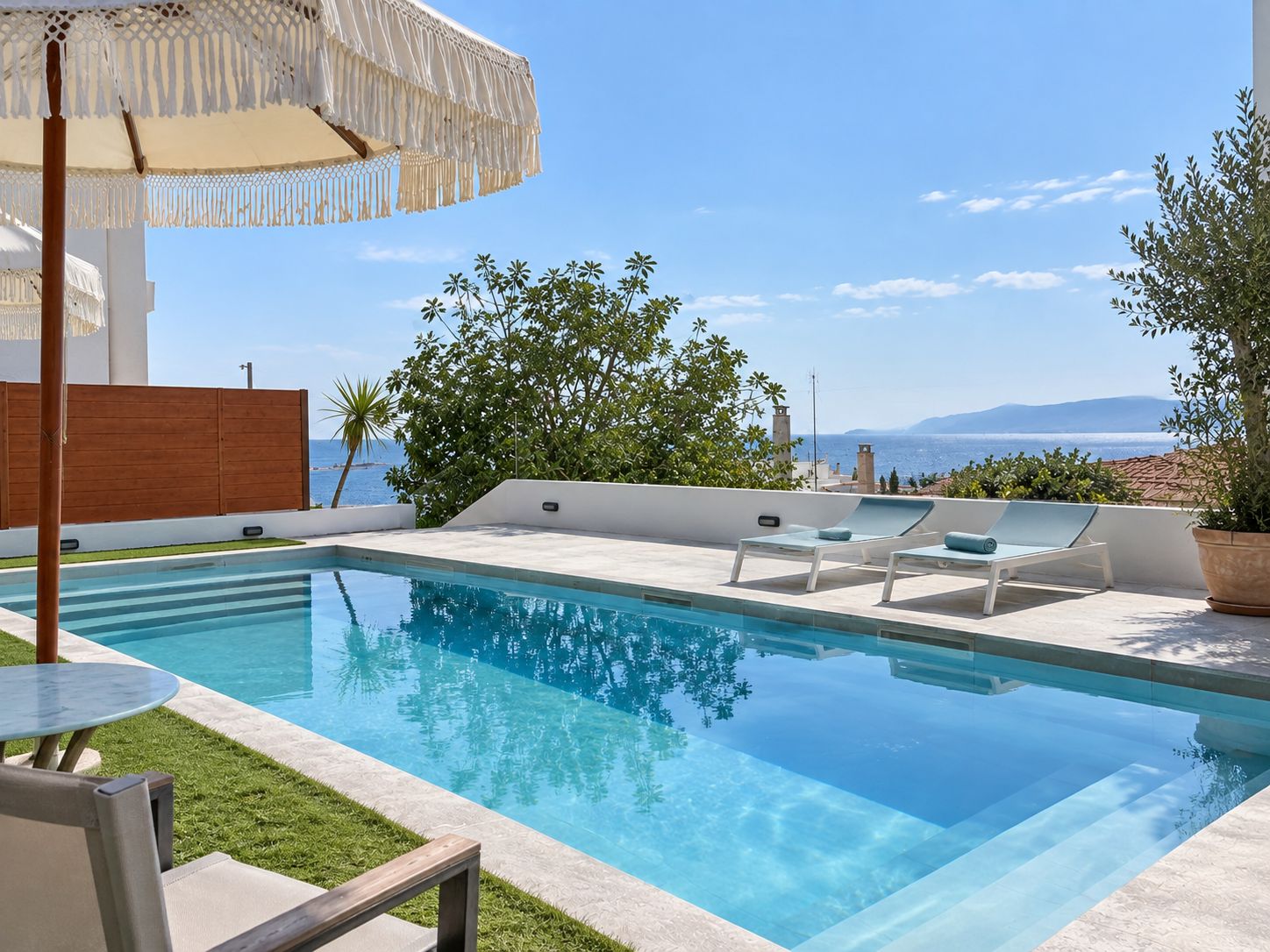 A modern outdoor pool area with lounge chairs and a pergola.