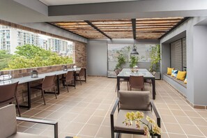 An outdoor patio with a dining table, chairs, and a view of the cityscape. - CITY STAR (Tolima)