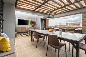 Un comedor moderno con una mesa grande, sillas y vistas a la ciudad a través del ventanal.