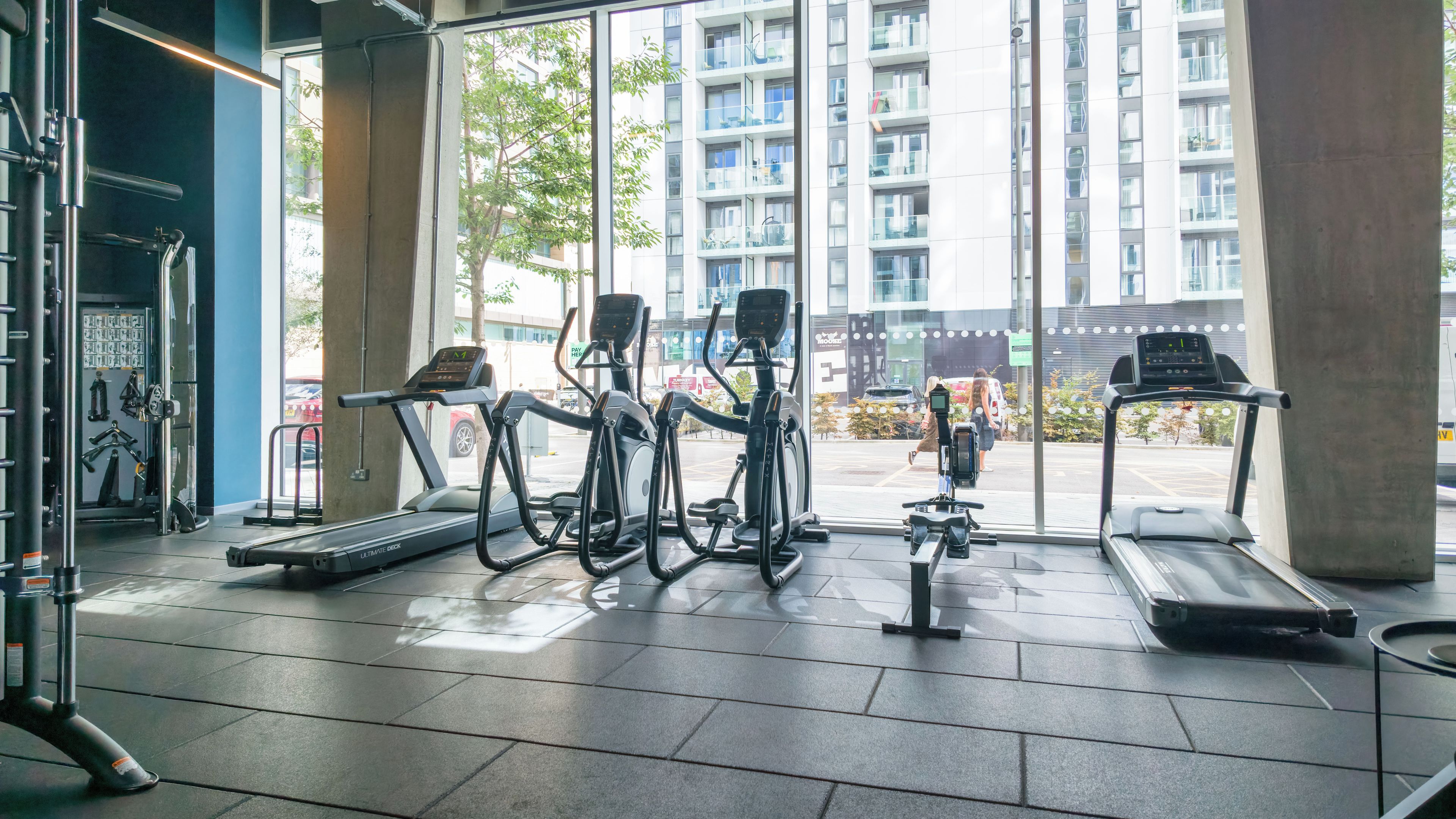 Un gimnasio con cintas de correr, elípticas y máquinas de pesas.