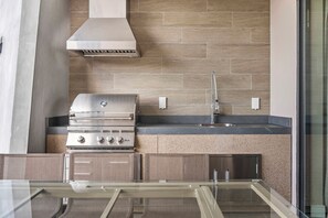 A modern kitchen with a stainless steel range, a built-in sink, and a backsplash of wooden tiles. - 4BR house sleeps 10 near Magic Village Views (Kissimmee)