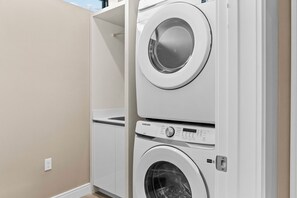 A laundry room with two stacked washing machines and a dryer. - 4BR house sleeps 10 near Magic Village Views (Kissimmee)