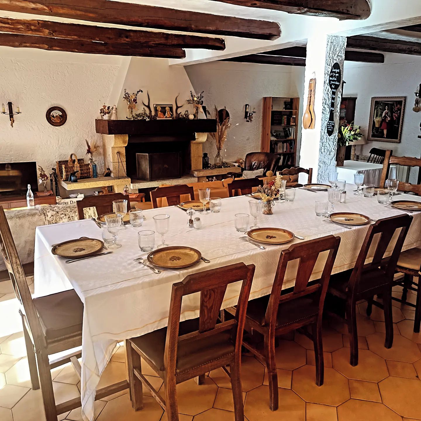 A dining area with a long table set for a meal, surrounded by chairs.