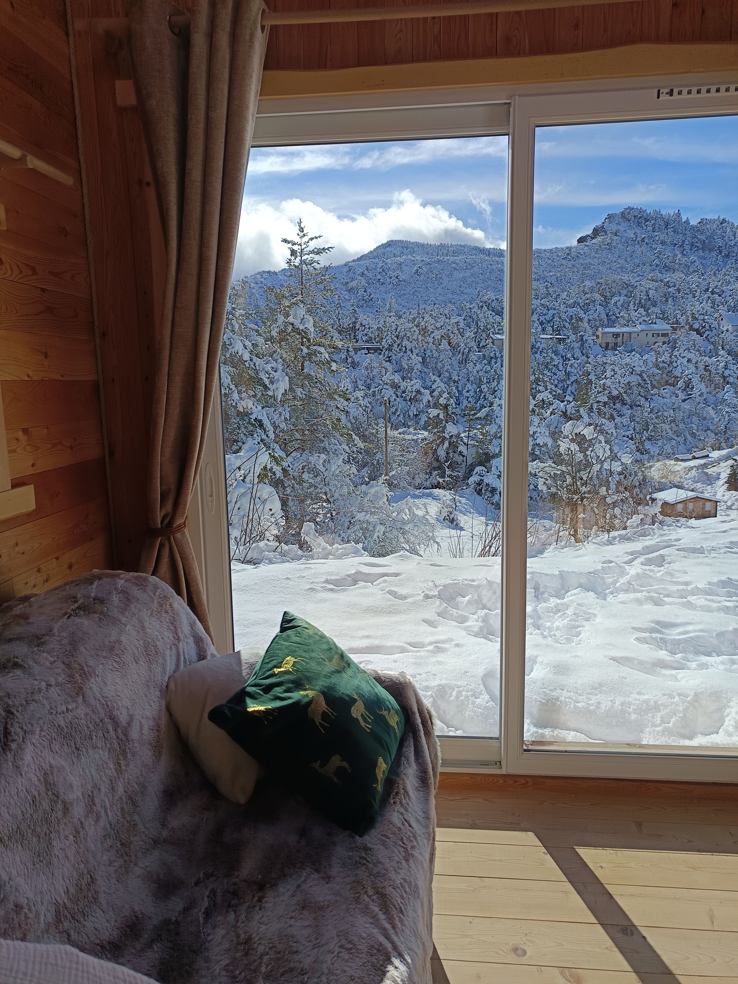 A room with a large window overlooking a snowy landscape.