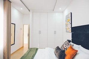 Una camera da letto con un letto, un armadio e un quadro appeso al muro.