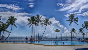 A swimming pool with palm trees and a view of the sea. - Waterfront RV lot in Venture Out Cudjoe Key, FL minutes to Blue Water & Key West (Cudjoe Key)