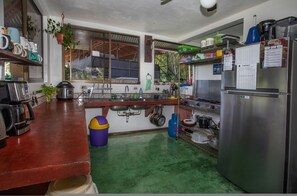 A compact kitchen with a refrigerator, sink, and various appliances.
