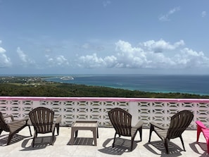 Una terraza con mobiliario exterior y vistas al mar.