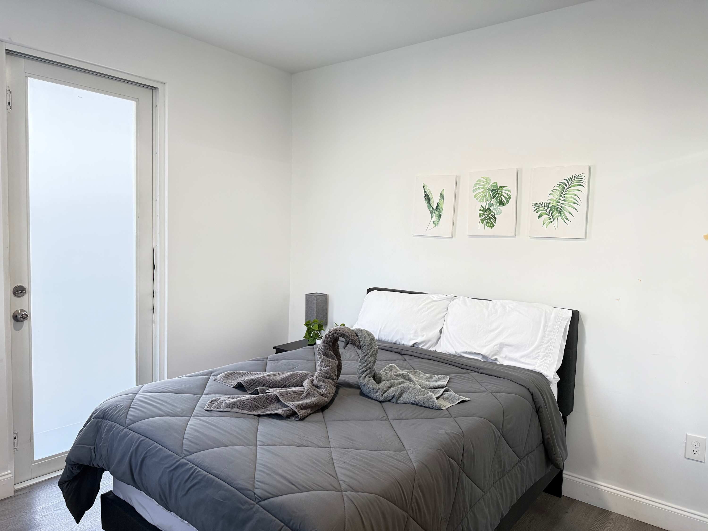 Ein Schlafzimmer mit einem Bett, einer Tür und Wandbildern.
