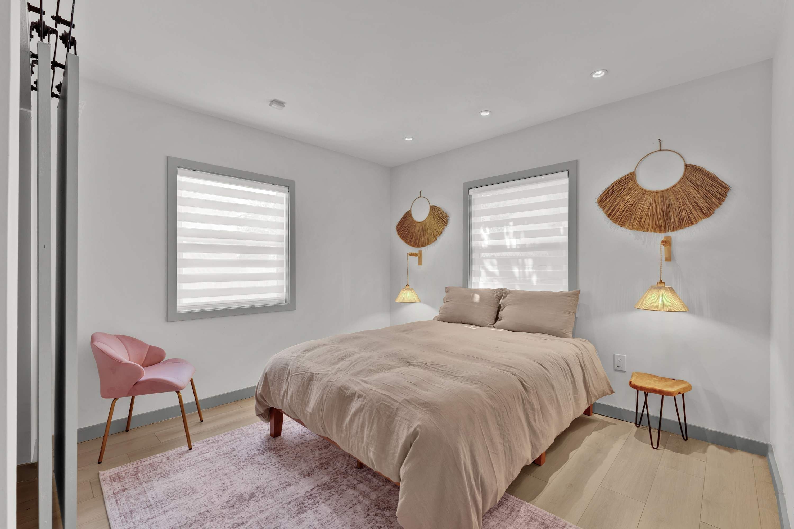 A bedroom with a bed, two bedside lamps, a chair, and a small table.