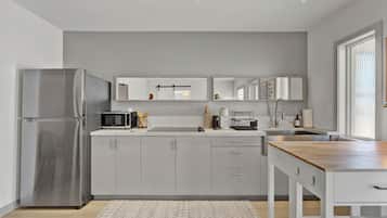 A modern kitchen with a stainless steel refrigerator, a microwave, and a sink.