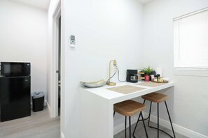 A compact kitchen with a microwave, refrigerator, and a small coffee maker on the counter. - Modern 4BR Villa Near Hollywood Beach FTL (Hollywood)