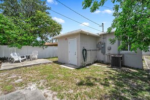 A small, single-story building with a white door and a small attached garage. - Modern 4BR Villa Near Hollywood Beach FTL (Hollywood)