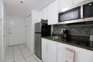 A modern kitchen with stainless steel appliances, a microwave, and a built-in oven. - Luxury Brickell Condo 1 BR Resort Amenities (Miami)