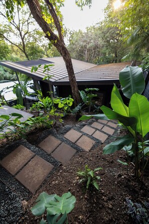 A garden pathway with stepping stones leading to a covered area with a sloped roof. - 2 Bedroom/ 2 Bathroom Treetop Home with Private Plunge Pool (Guanacaste Province)