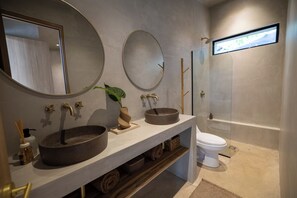 A modern bathroom with a large mirror, two sinks, a toilet, and a shower. - 2 Bedroom/ 2 Bathroom Treetop Home with Private Plunge Pool (Guanacaste Province)
