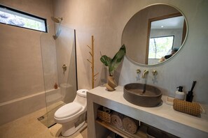 A modern bathroom with a toilet, shower, and sink. - 2 Bedroom/ 2 Bathroom Treetop Home with Private Plunge Pool (Guanacaste Province)