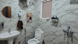 Een badkamer met toilet, wastafel en douche.