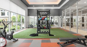 Un gimnasio con equipo de ejercicio, una barra de dominadas y un soporte para pesas.