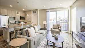 Un apartamento moderno con cocina, comedor, sala de estar y balcón.