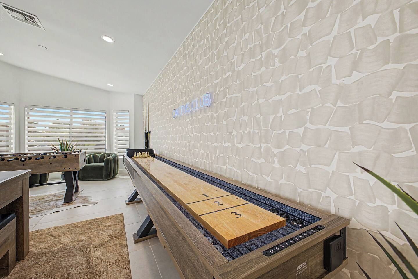 Een biljarttafel met een houten tafelblad en een gestructureerde muur ernaast.