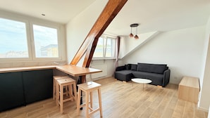En modern lägenhet i loftstil med kök, matplats och sittgrupp.