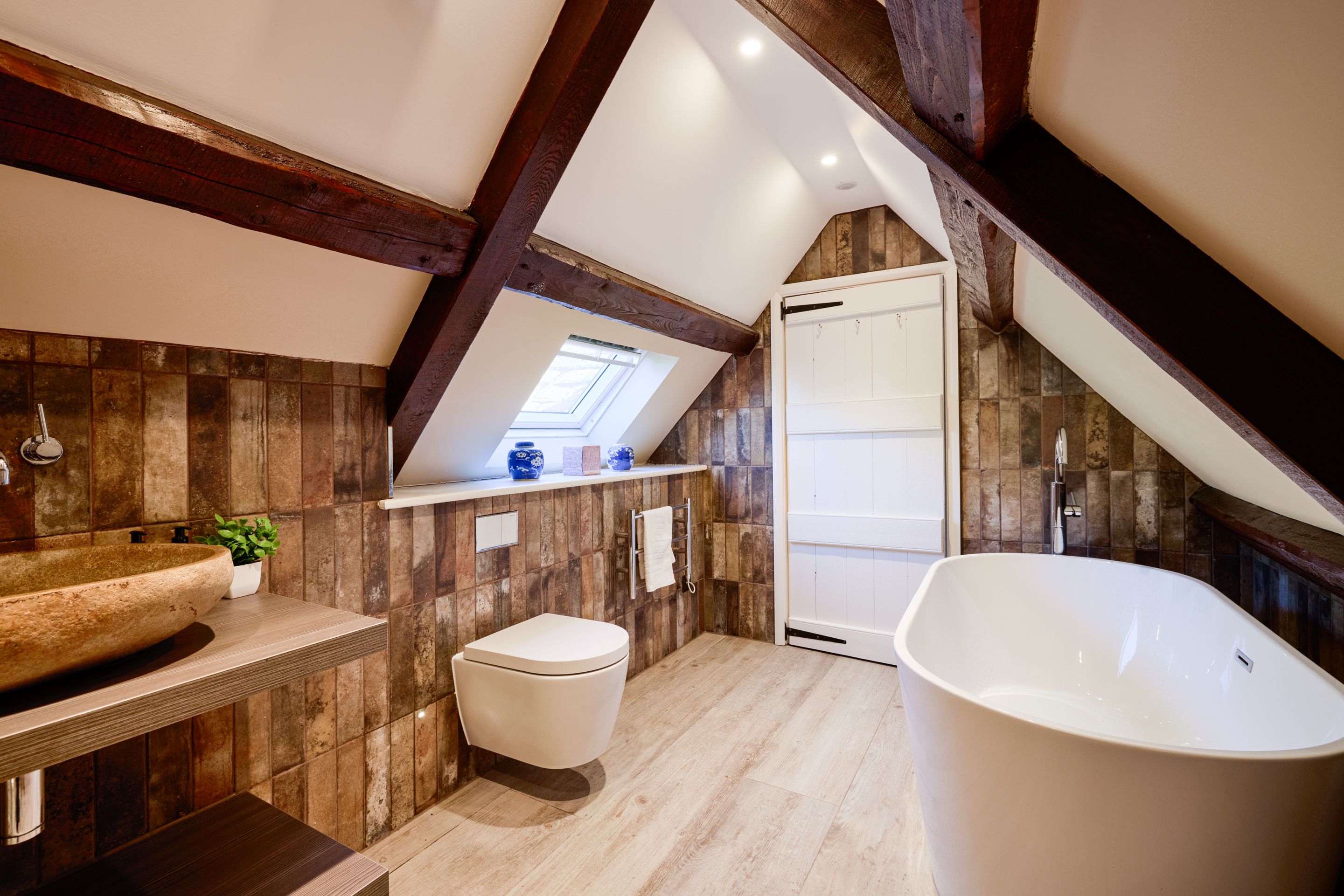 A modern bathroom with a freestanding bathtub, a toilet, and a vanity with a sink.
