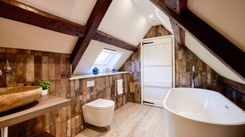 A modern bathroom with a freestanding bathtub, a toilet, and a vanity with a sink.