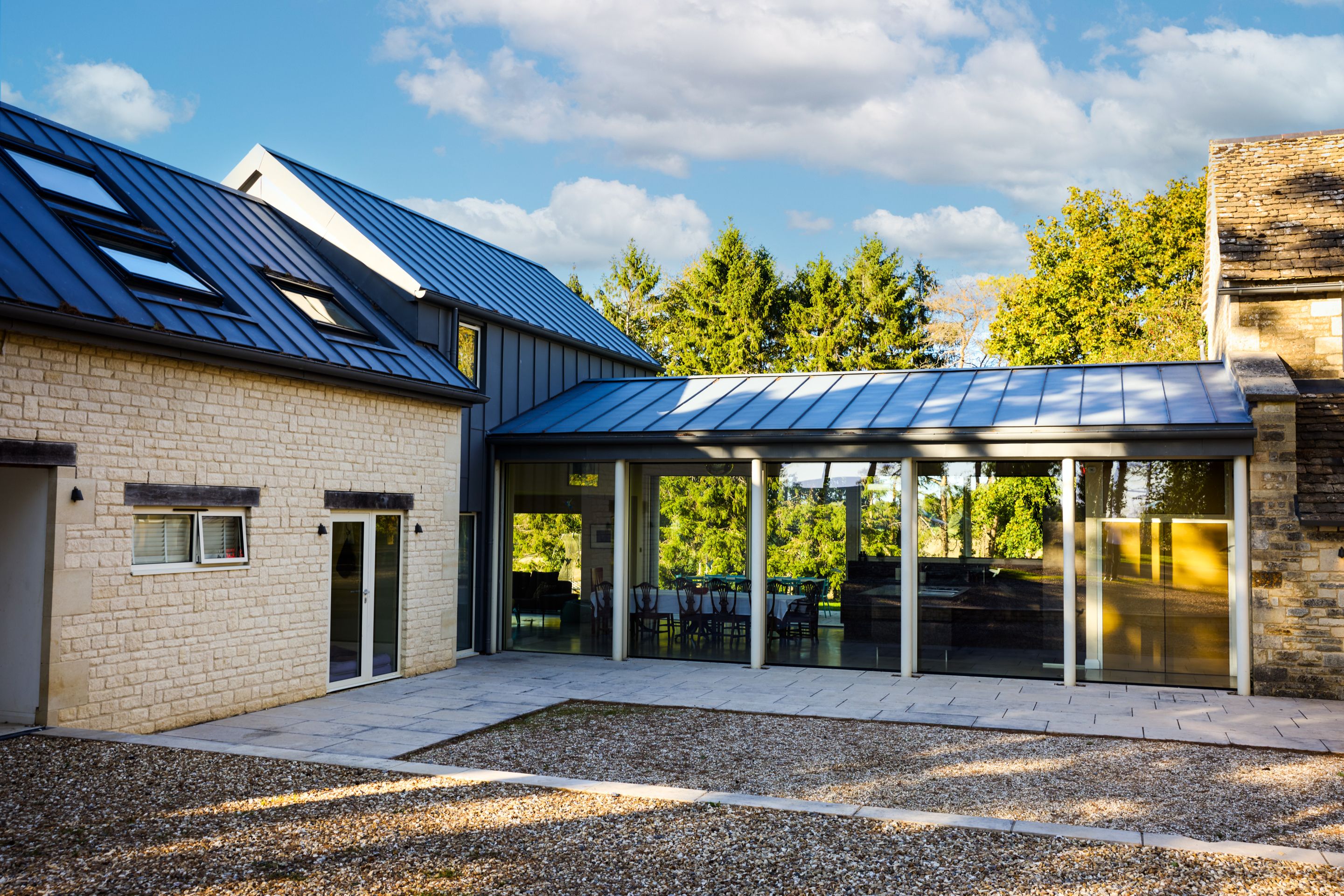 Una casa moderna con veranda coperta, rivestimento in mattoni e tetto in metallo.