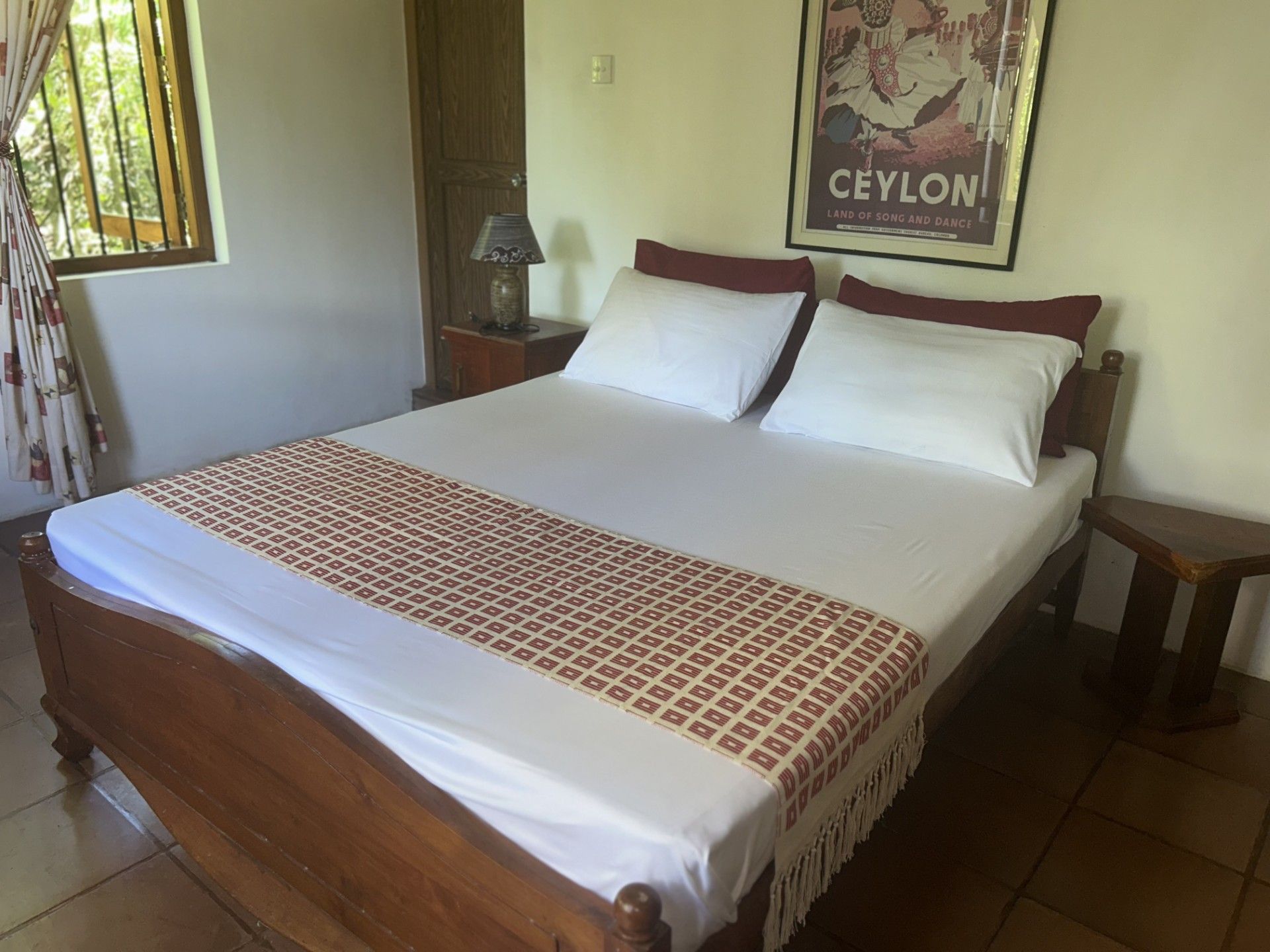 Un grand lit avec une couvre-lit à motifs, deux oreillers et une tête de lit en bois.