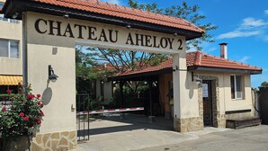 Chateau Aheloy 2 with a sign above the entrance, a tiled roof, and a stone wall. - Chateau apartment (Aheloy)