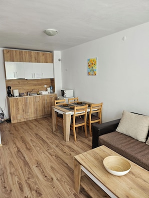 A compact living space with a kitchenette, dining area, and seating area.