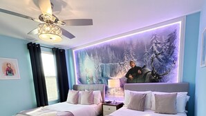 A bedroom with two beds, a ceiling fan, a wall mural, and a window with curtains. - Spacious 9-bedroom house in fantastic Four Corners with AC (Four Corners)