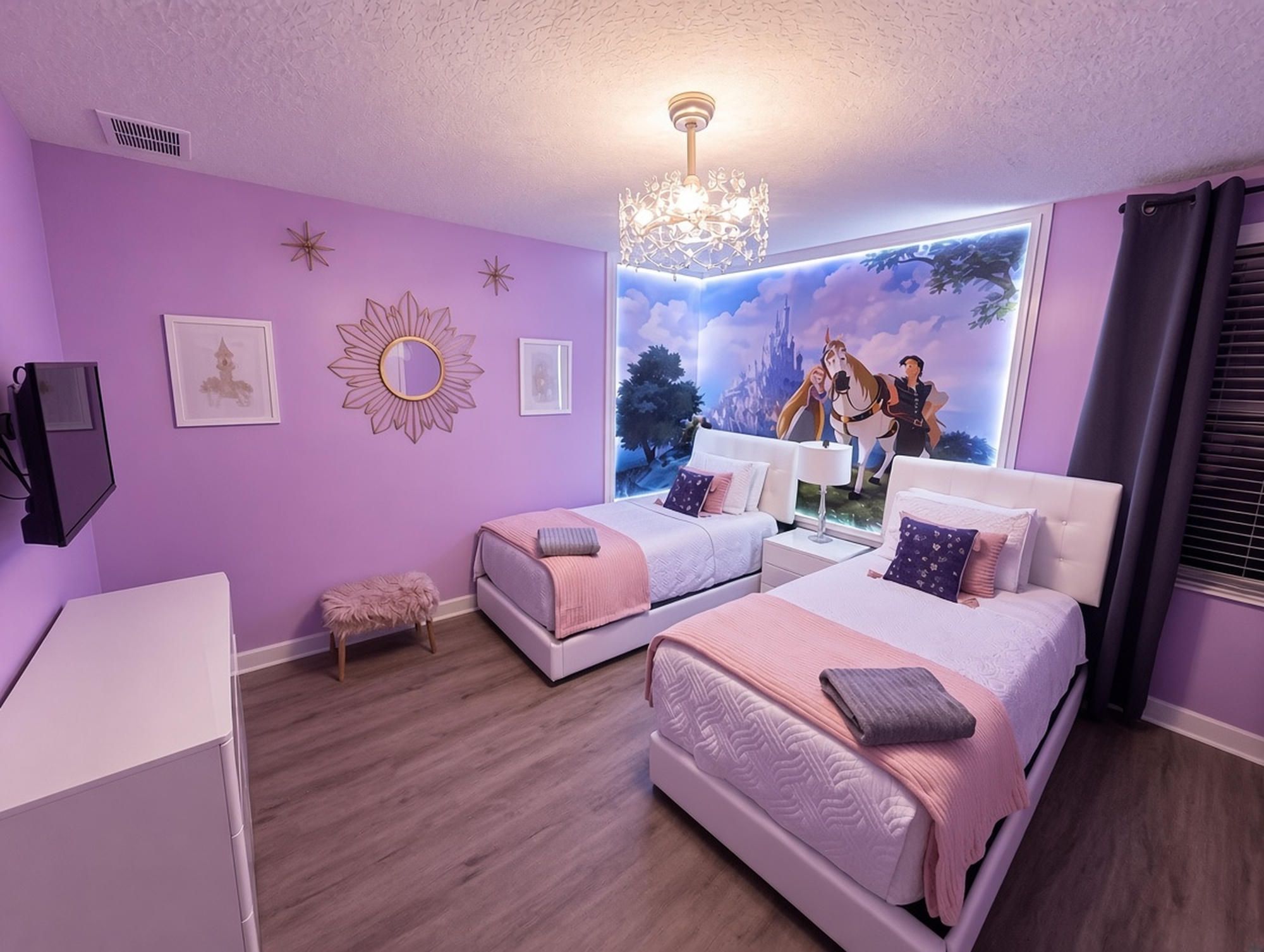 A bedroom with two beds, a chandelier, a mural, and a window with curtains.