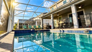 An indoor swimming pool with clear glass walls, a tiled deck, and a ceiling fan. - Spacious 9-bedroom house in fantastic Four Corners with AC (Four Corners)