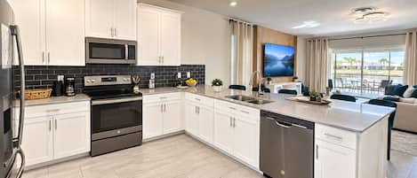A modern kitchen with white cabinetry, a built-in microwave, and a dishwasher.