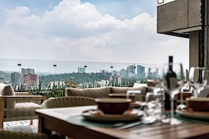 Ein Essbereich mit Blick auf die Stadt, inklusive Gebäude und einer Seilbahn.