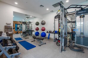 A gym with weightlifting equipment, exercise balls, and a squat rack. - Cozy 2BR | 2BA • Pool • Gym • Free Parking A1 (Phoenix)