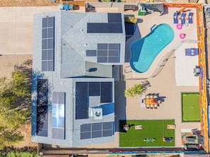 Eine Vogelperspektive eines Gebäudes mit Swimmingpool, Solaranlage und Außenbereich zum Sitzen.