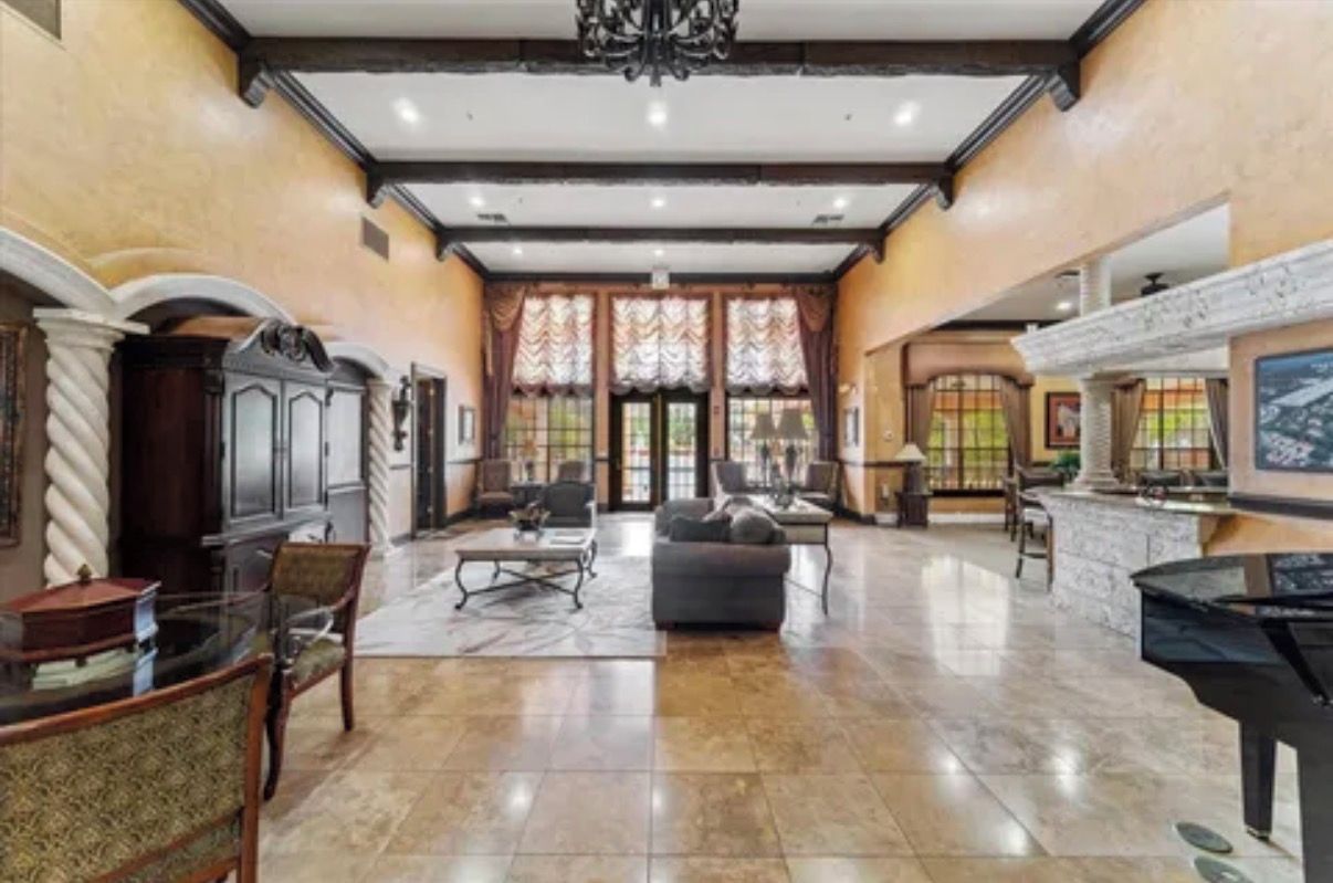 A spacious lobby with a grand piano, comfortable seating, and a fireplace.