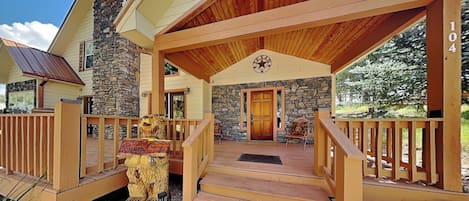 A lodge with a stone facade, wooden porch, and a Texan star emblem.
