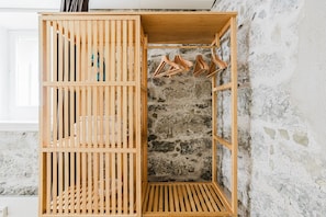 Ein Holzschrank mit mehreren Fächern, darunter Kleiderstangen.
